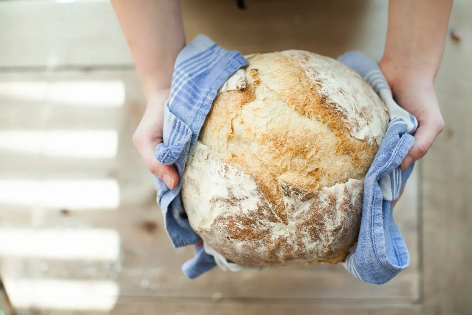 Una pagnotta appena sfornata tenuta in mano